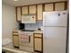 Efficient kitchen with white appliances, including a microwave, stove, and refrigerator, for easy meal preparation at 4016 Oakview Dr # J6, Punta Gorda, FL 33980