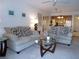 Bright living room featuring comfortable sofas, a glass coffee table, and seamless flow to the kitchen area at 4016 Oakview Dr # J6, Punta Gorda, FL 33980