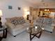 Inviting living room featuring plush sofas, a glass coffee table, and open access to the kitchen at 4016 Oakview Dr # J6, Punta Gorda, FL 33980