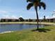 Scenic waterfront view of tan condos with a serene pond and palm trees under a blue sky at 4016 Oakview Dr # J6, Punta Gorda, FL 33980