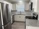 Modern kitchen with stainless steel appliances, white cabinets, and granite countertops at 4031 Wake Ave, Sarasota, FL 34241