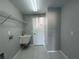 An interior laundry room is equipped with a utility sink and shelving unit at 4031 Wake Ave, Sarasota, FL 34241