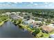 Aerial view of home with screened pool, lake view, and lush surrounding landscape at 4426 Useppa Dr, Bradenton, FL 34203