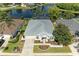 An aerial view of a home featuring a well-maintained lawn, landscaping, and serene lake views at 4426 Useppa Dr, Bradenton, FL 34203