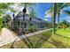 Lush backyard landscaping featuring a screened-in pool area and meticulous lawn at 4426 Useppa Dr, Bradenton, FL 34203