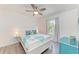 Cozy bedroom featuring queen-size bed, wood-look flooring, a ceiling fan, and natural light from the window at 4426 Useppa Dr, Bradenton, FL 34203