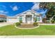 Charming single-story home with a well-manicured lawn, landscaped garden beds, and attached two-car garage at 4426 Useppa Dr, Bradenton, FL 34203