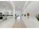 Elegant hallway featuring arched entryways, neutral tile flooring, and decorative plants, offering a bright, airy feel at 4426 Useppa Dr, Bradenton, FL 34203