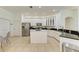 Bright kitchen with white cabinets, island, modern appliances, and neutral tile flooring at 4426 Useppa Dr, Bradenton, FL 34203