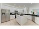 Bright, white kitchen featuring stainless steel appliances, a kitchen island, and dark countertops at 4426 Useppa Dr, Bradenton, FL 34203