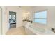 Main bathroom featuring a soaking tub, vanity, and view into the main bedroom at 4426 Useppa Dr, Bradenton, FL 34203