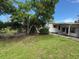 Landscaped yard with mature trees surrounding a quaint single-story home at 4845 Boca Raton Ave, Sarasota, FL 34234
