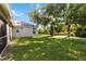 Spacious backyard with lush lawn and mature trees surrounding the property at 4845 Post Pointe Dr, Sarasota, FL 34233