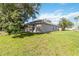 Large backyard showing the home's exterior, a green lawn, and shade trees at 4845 Post Pointe Dr, Sarasota, FL 34233