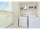 Laundry room featuring a washer, dryer, window with blinds and wire shelving at 4845 Post Pointe Dr, Sarasota, FL 34233