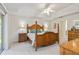 Main bedroom with wooden four-poster bed, ceiling fan, and carpet at 4845 Post Pointe Dr, Sarasota, FL 34233