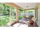 Screened porch with outdoor furniture and view of the green backyard at 4845 Post Pointe Dr, Sarasota, FL 34233