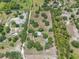 Lush aerial view showcasing a sprawling property with mature trees, surrounding landscapes, and proximity to other homes at 5034 257Th E St, Myakka City, FL 34251