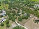 Lush aerial view of an expansive property featuring a home, outbuildings, and a serene pond at 5034 257Th E St, Myakka City, FL 34251