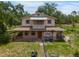 Two-story home with a large front porch and screened-in balcony, nestled amongst mature trees at 5034 257Th E St, Myakka City, FL 34251