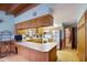 Charming kitchen featuring warm wood cabinets, a breakfast bar, and ample counter space at 5034 257Th E St, Myakka City, FL 34251
