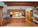 Bright living area featuring open kitchen access, exposed wood beams, and natural light at 5034 257Th E St, Myakka City, FL 34251
