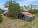 A weathered shed with a rusty roof complements a rustic home, blending charm and character at 5034 257Th E St, Myakka City, FL 34251