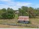 An older shed located on a tree-lined property with a two-story home in the background at 5034 257Th E St, Myakka City, FL 34251