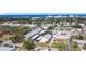 Aerial view showcases a coastal neighborhood with lush greenery and the shimmering ocean in the backdrop at 516 Parkdale Mews # 516, Venice, FL 34285