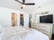 Bright bedroom with bed, TV on drawers, ceiling fan, and wood floor at 516 Parkdale Mews # 516, Venice, FL 34285