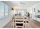 Bright dining area features a long wooden table with seating and an open view into the living room at 516 Parkdale Mews # 516, Venice, FL 34285