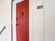 Close-up of a vibrant red front door with digital lock, smart features, and unit number 516 at 516 Parkdale Mews # 516, Venice, FL 34285