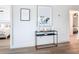 Hallway displaying modern console table, artworks, and access to the bedroom, providing style and functionality at 516 Parkdale Mews # 516, Venice, FL 34285