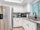 Bright kitchen featuring white cabinets, granite countertops, and stainless steel appliances at 516 Parkdale Mews # 516, Venice, FL 34285