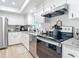 Modern kitchen with stainless steel appliances, granite countertops, and white cabinets at 516 Parkdale Mews # 516, Venice, FL 34285
