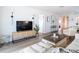 Bright living room featuring a modern media cabinet and a view into the dining room, offering comfort and style at 516 Parkdale Mews # 516, Venice, FL 34285