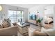 Bright living room with natural light, a comfortable sectional sofa and open access to the balcony at 516 Parkdale Mews # 516, Venice, FL 34285