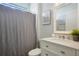 Bathroom features a modern vanity, elegant mirror, and a shower with a gray shower curtain at 5419 Lakehurst Ct, Palmetto, FL 34221