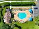 An aerial view of a beautiful community pool surrounded by lush greenery, seating, and umbrellas at 5419 Lakehurst Ct, Palmetto, FL 34221