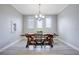 Elegant dining room with three large windows, rustic wooden table, and modern lighting at 5419 Lakehurst Ct, Palmetto, FL 34221