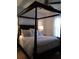 Comfortable bedroom with a stately four-poster bed, plush bedding, and soft lighting at 5449 Downham Mdws, Sarasota, FL 34235