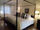 Spacious bedroom with a four-poster bed, soft white linens, and natural light from large windows at 5449 Downham Mdws, Sarasota, FL 34235