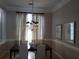 Elegant dining room with a chandelier, large windows, and neutral-toned walls at 5449 Downham Mdws, Sarasota, FL 34235