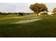 Picturesque golf course view with sand traps, water, and mature trees with rainbow at 5449 Downham Mdws, Sarasota, FL 34235