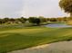 Scenic view of golf course with pond, flag, and green grass, plus a rainbow at 5449 Downham Mdws, Sarasota, FL 34235