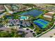 Aerial view of the community clubhouse with pool, tennis courts, and a beautiful lake nearby at 5750 Long Shore Loop, Sarasota, FL 34238