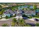 Aerial view of the community clubhouse with dark gray roof and nearby lake and other amenities at 5750 Long Shore Loop, Sarasota, FL 34238