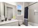 Bright bathroom with white vanity, tiled shower, and black and white shower curtain at 5750 Long Shore Loop, Sarasota, FL 34238