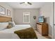 Cozy bedroom with a wood-frame bed, ceiling fan, and a view of the backyard through a window at 5750 Long Shore Loop, Sarasota, FL 34238