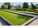 Bocce ball court with artificial turf and surrounding landscape at 5750 Long Shore Loop, Sarasota, FL 34238